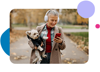 Lady with headphones holding a dog on her phone