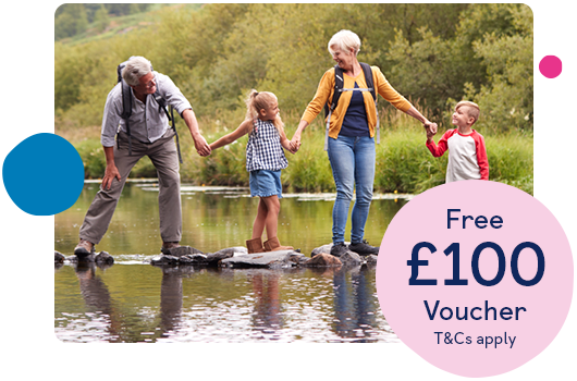 Family standing in a line on stepping stones in river holding hands
