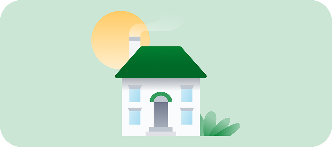 The sun behind a white house with a green roof and bushes.